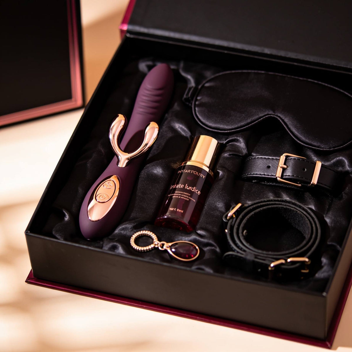 Premium adult toy gift set featuring a luxury vibrator, intimate lubricant, satin eye mask and black restraint accessories with elegant rose-gold detailing, presented in a black satin-lined gift box.